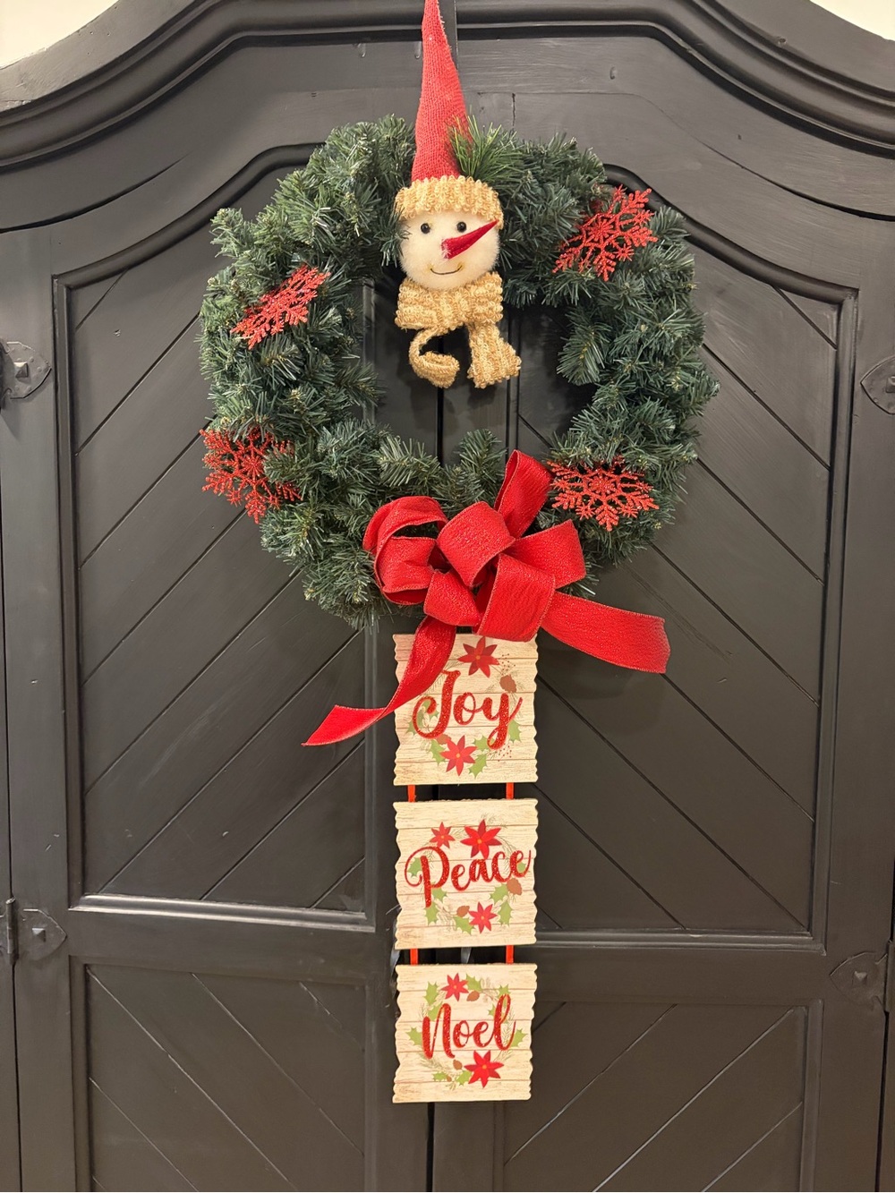 Festive Green Holiday Wreath with Red Accents and Hanging Signs